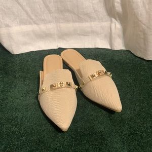 Cream pointed toe mules.